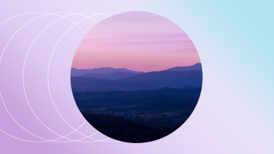 Purple and blue mountain range cropped to a circle in front of a light pink and blue gradient background