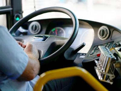 View of a public transit bus driver with hands on the wheel